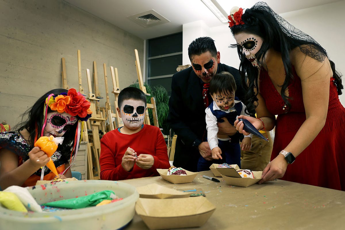 The Gonzales family - Marilena, left to right, Lucius, Tommy, Lino (babe) and Ivy, decorate sugar skulls on Nov. 1 at the FAC during Dia De Muertos. Photo by Jamie Cotten / Colorado College